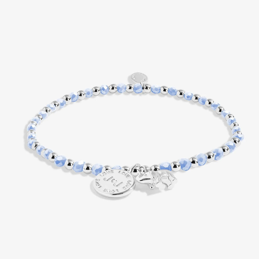 Bracelet with alternating silver and blue crystal beads. Features two charms: A silver elephant, and a silver round Joma Jewellery charm. 