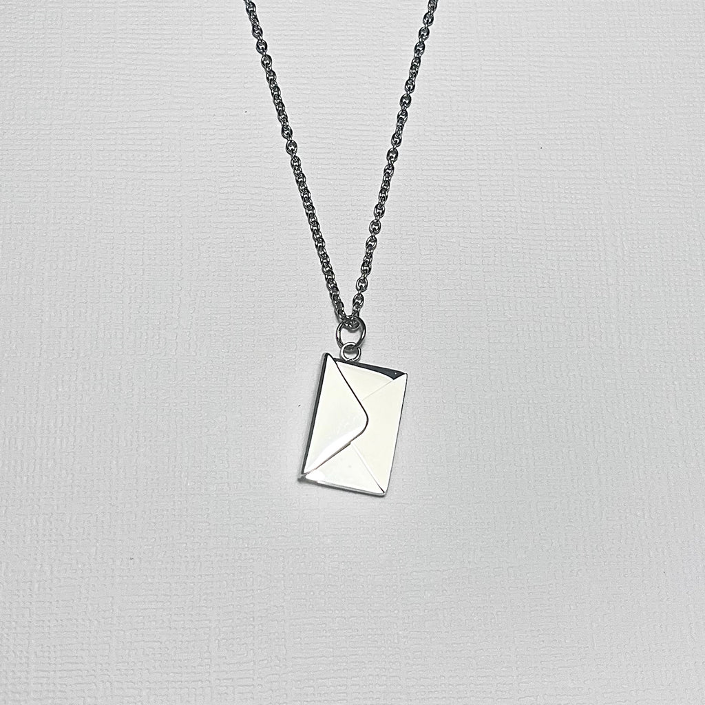 Silver necklace with envelope charm closed.