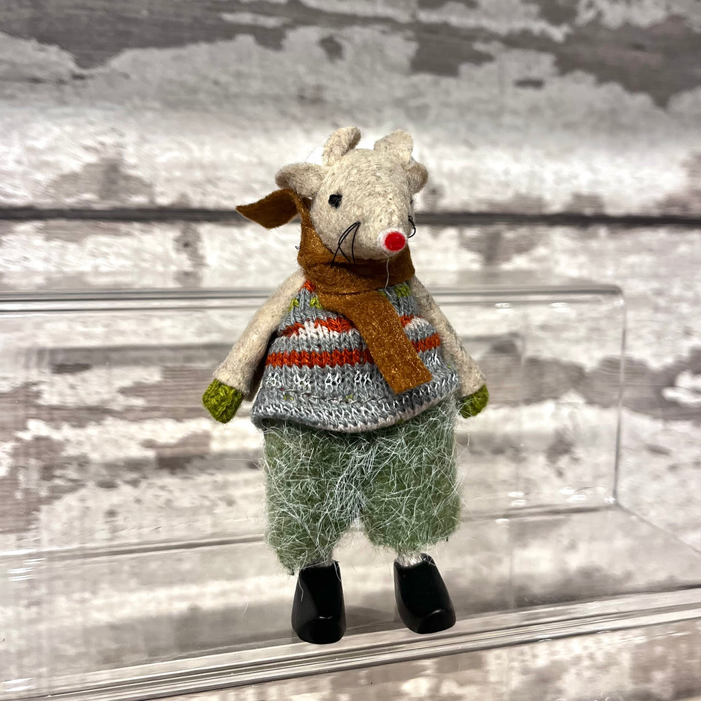 Toy mouse wearing a sweater and scarf on a textured surface