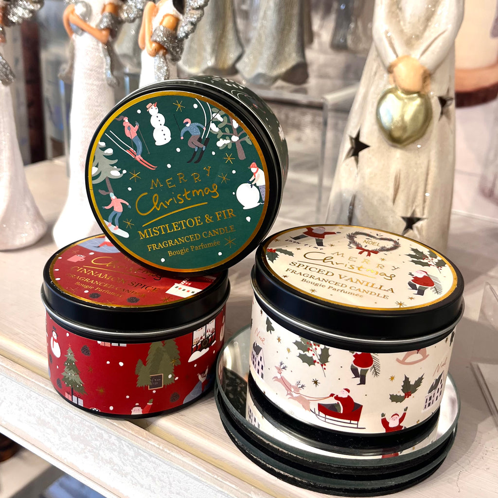 Three Christmas-themed tins with decorative labels on a shelf.