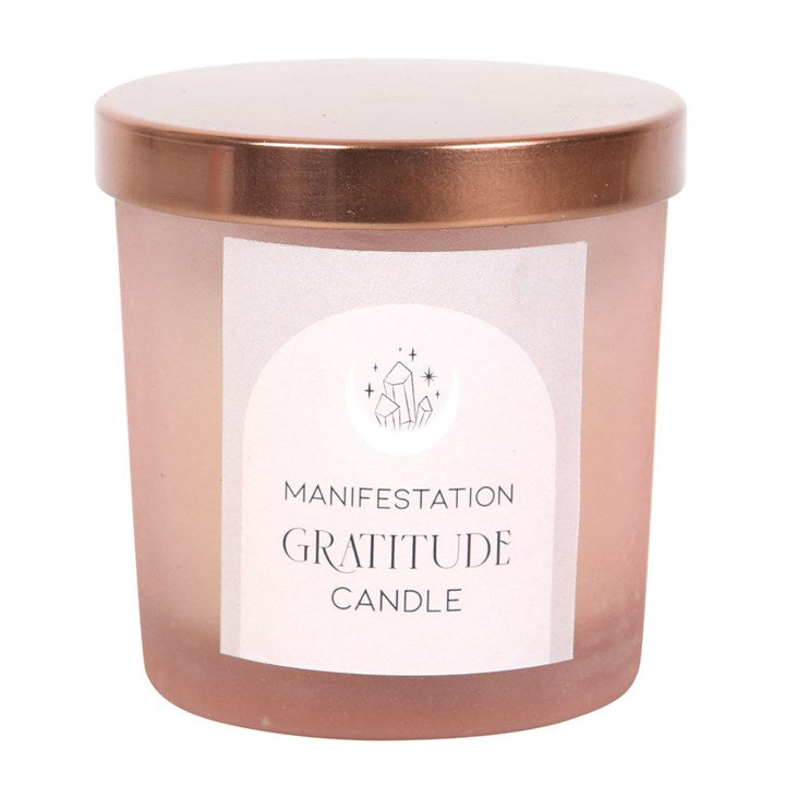 Pink frosted glass candle with copper-tone lid. Inside is a white candle with small rose quartz crystals embedded into the wax. 