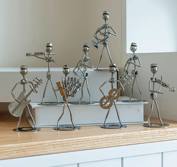 Metal stick figure standing ornaments, individually holding a different instrument. Instruments included: Saxophone, violin, french horn, guitar, accordion, trumpet, flute, bass guitar.