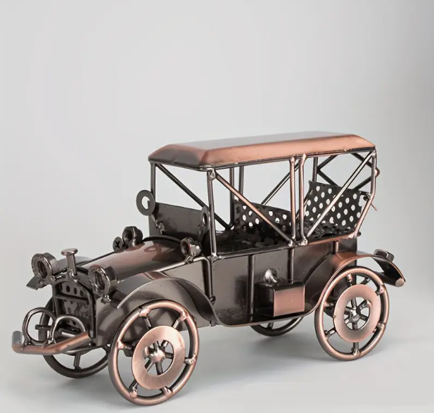 Vintage model car with moving wheels in a dark metal with bronze/copper accents.
