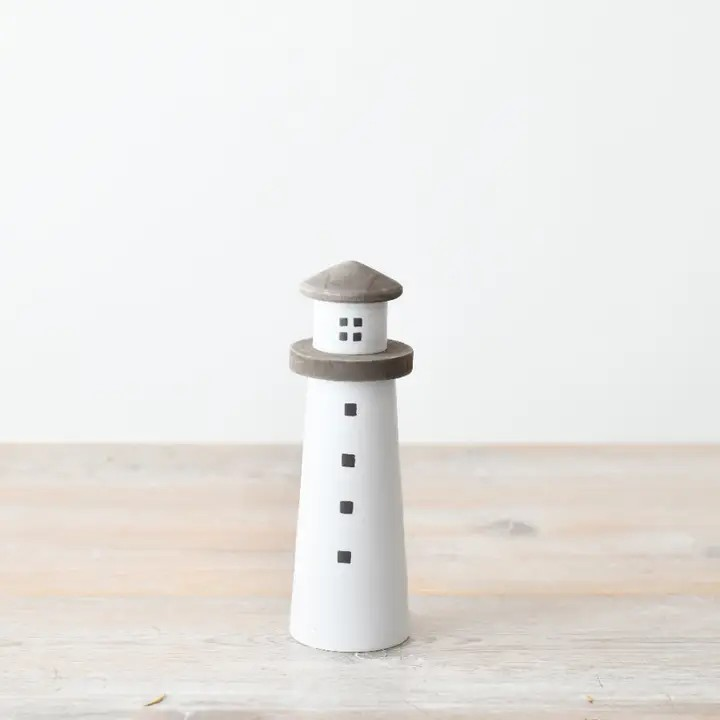White minimalist lighthouse wooden ornament with grey accents and some small square black windows.