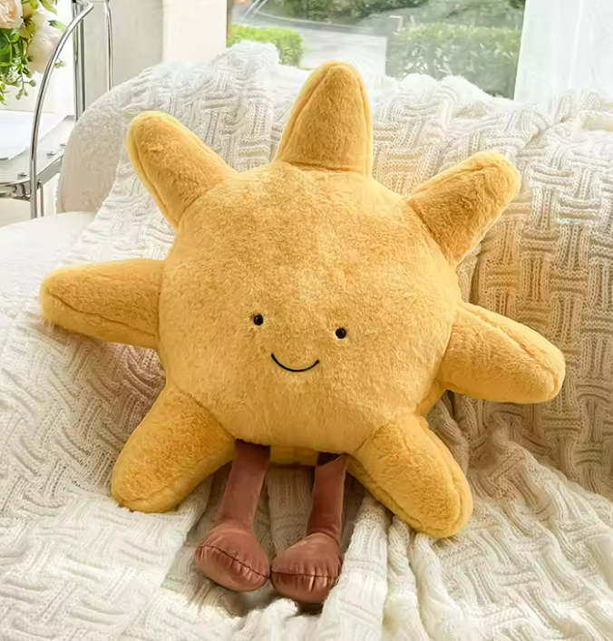 Plush cartoon yellow sunshine with brown legs and a small smiling face 