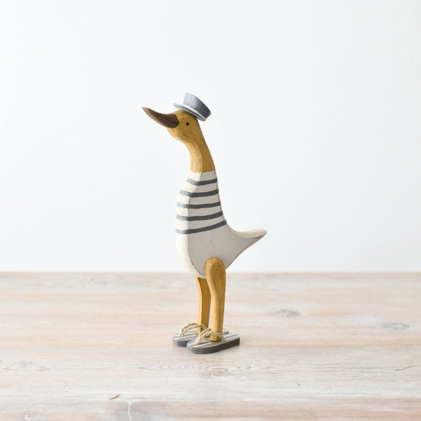 A fisherman style suck with wooden brown features, a white and blue stripey jumper (with no arms), a blue fisherman hat, and blue and white striped flip flops. 